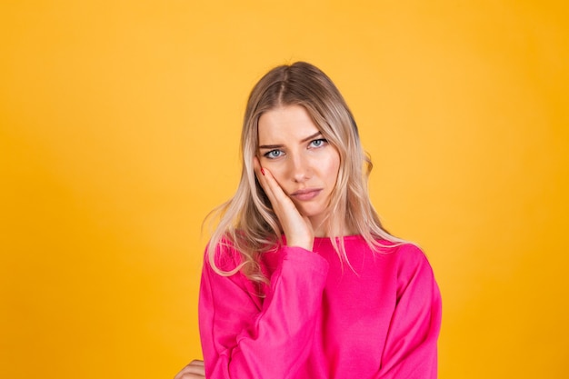 Hübsche europäische Frau in der rosa Bluse auf gelber Wand