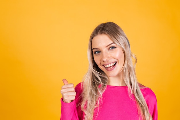 Hübsche europäische Frau in der rosa Bluse auf gelber Wand