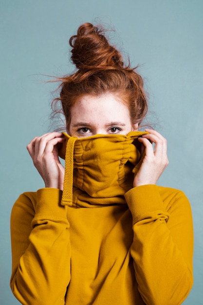 Kostenloses Foto hübsche frau des mittleren schusses mit haarknoten und grauem hintergrund