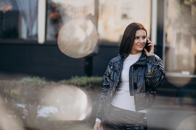 Hübsche Frau, die draußen Telefon im Park verwendet