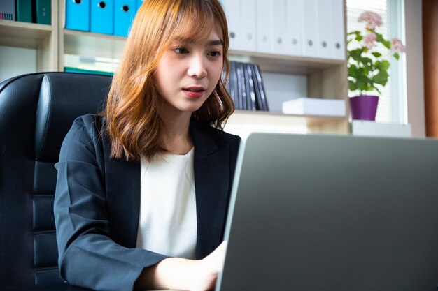 Hübsche Frau, die im Büro arbeitet