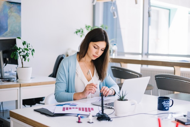 Hübsche Frau, die im Büro arbeitet