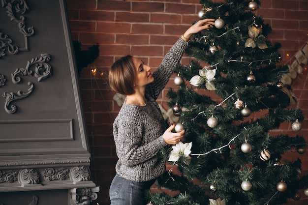 Hübsche Frau, die Weihnachtsbaum verziert