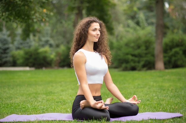 Hübsche Frau, die Yoga-Meditation in der Lotussitz macht