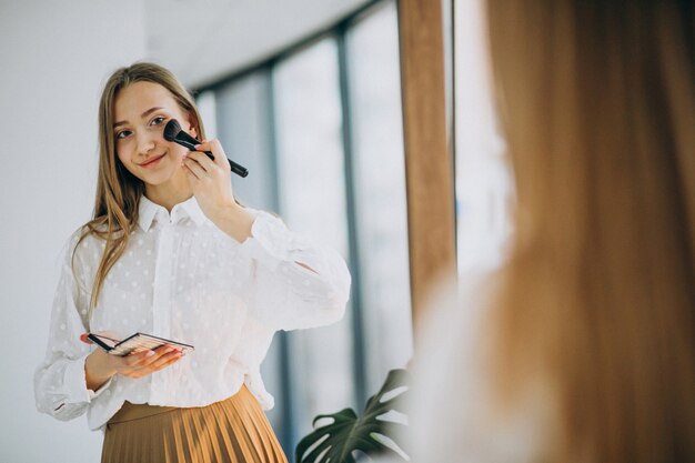 Hübsche Frau, die zu Hause Make-up macht