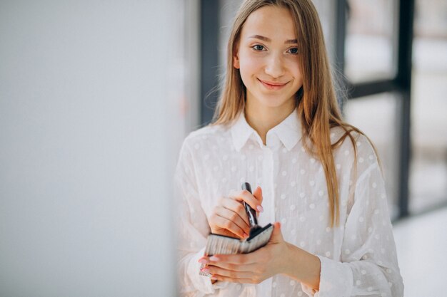 Hübsche Frau, die zu Hause Make-up macht