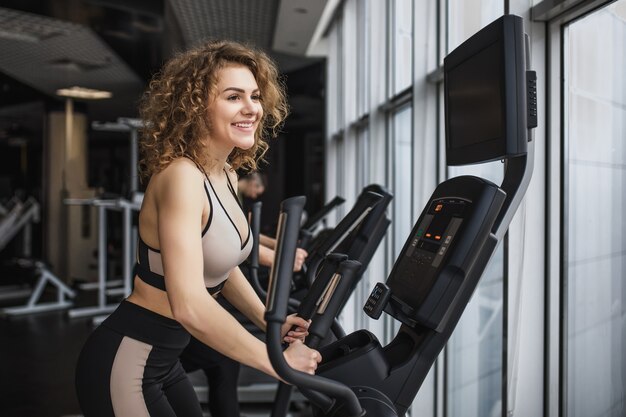 Hübsche Frau im Fitnessstudio, die Sport macht