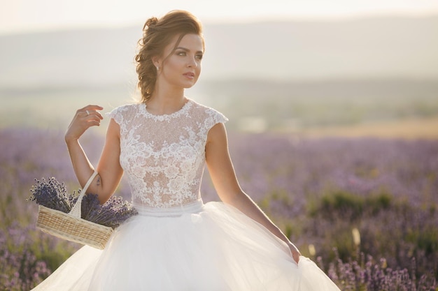 hübsche Frau im Hochzeitskleid im Lavendelfeld