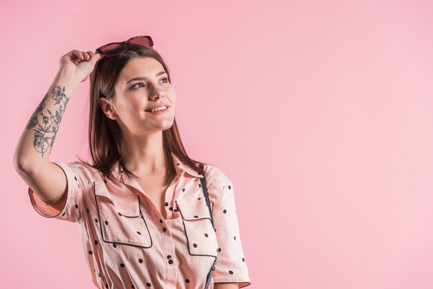 Hübsche Frau im Kleid auf rosa Hintergrund