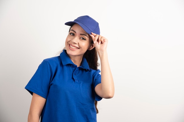 Hübsche Frau in blauer Uniform berührt ihr Gesicht mit der Hand. Foto in hoher Qualität