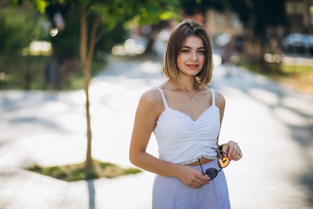 Hübsche Frau in der Sommerausstattung im Park