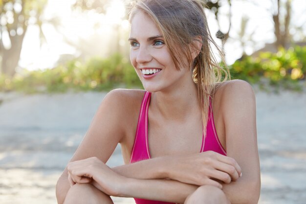 Hübsche Frau in der Sportbekleidung am Strand