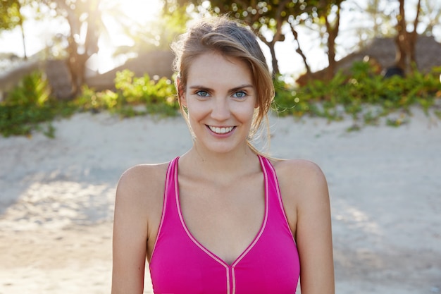 Hübsche Frau in der Sportbekleidung am Strand