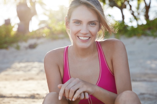 Hübsche Frau in der Sportbekleidung am Strand