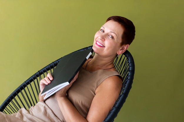 Hübsche Frau mit dem kurzen Haar, das eine Zeitschrift hält