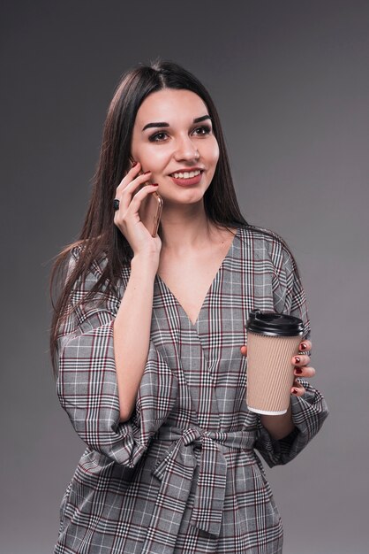 Hübsche Frau mit der Schale, die am Telefon spricht