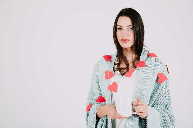 Hübsche Frau mit Herzen und Cup im Studio