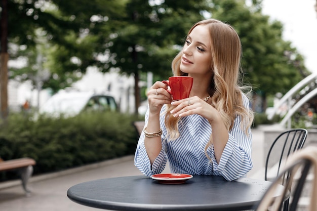 hübsche Frau mit Kaffee im Terrassencafé in der Stadt