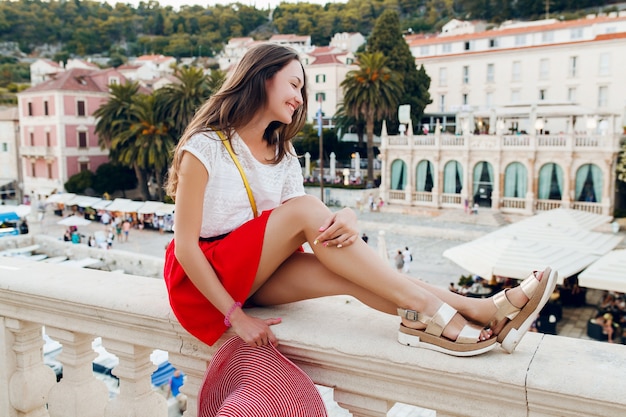 Hübsche Frau mit rotem Hut auf Urlaubsbeinen in Sandalen