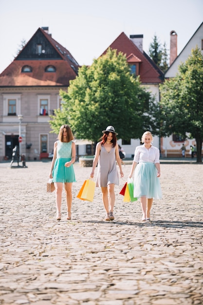 Hübsche Frauen, die mit Papiertüten gehen