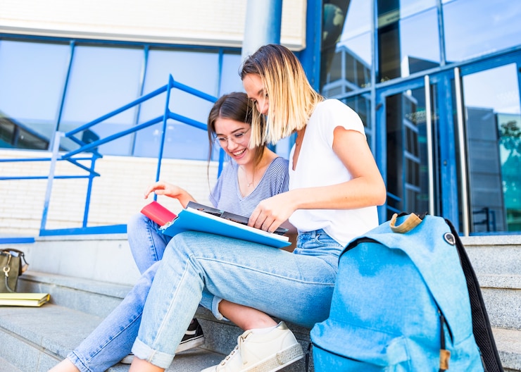Kostenlose Foto hübsche frauen, die nahe hochschulgebäude studieren