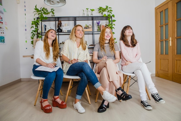 Hübsche Frauen sitzen zusammen im Büro