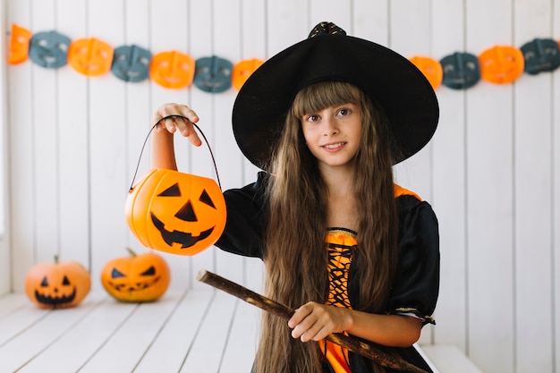 Hübsche Halloween-Hexe mit gruseliger Laterne und Besen