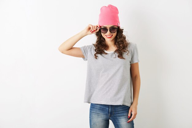 Hübsche hübsche Hipster-Frau in rosa Hut, Sonnenbrille, tanzendes fröhliches, lächelndes Gesicht, langes Haar, positive Stimmung, emotionales Outfit im Hipster-Stil, Sommermodetrend, Jeans und gestreiftes T-Shirt, isoliert