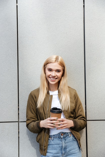 Hübsche junge Blondine, die Tasse Kaffee hält