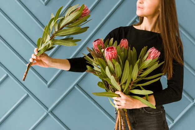 Hübsche junge Frau der Nahaufnahme, die einen Blumenstrauß hält