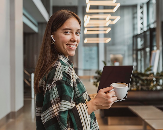 Hübsche junge Frau, die eine Kaffeepause genießt