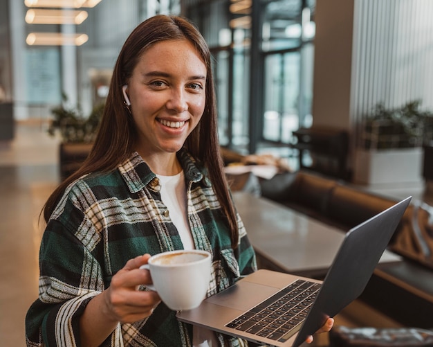 Kostenloses Foto hübsche junge frau, die eine kaffeepause genießt