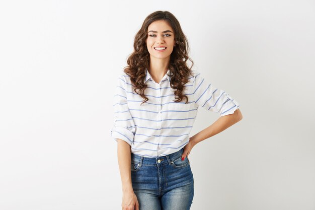 Hübsche junge Frau mit offenem Lächeln, Hipster-Stil, gekleidet in Jeans, Hemd, lokalisiert auf weißem Hintergrund, lockiges Haar