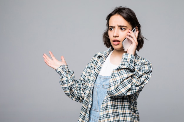 Kostenloses Foto hübsche junge lächelnde frau, die am telefon spricht