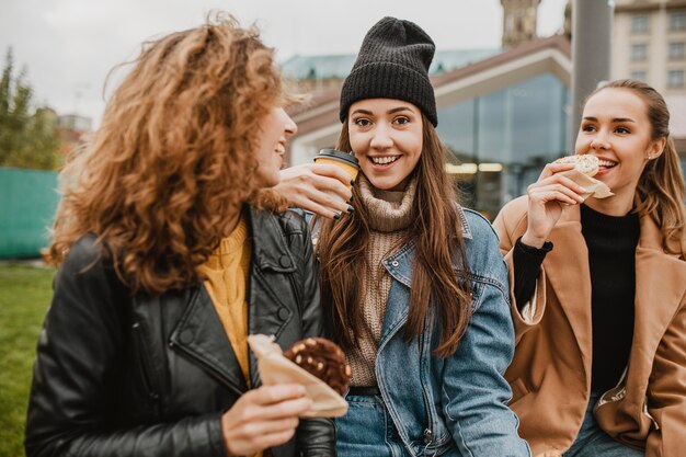Hübsche junge Mädchen, die zusammen Süßigkeiten genießen