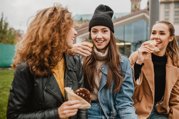 Hübsche junge Mädchen, die zusammen Süßigkeiten genießen