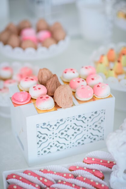 Hübsche kleine rosa und weiße Kuchen und Eclairs