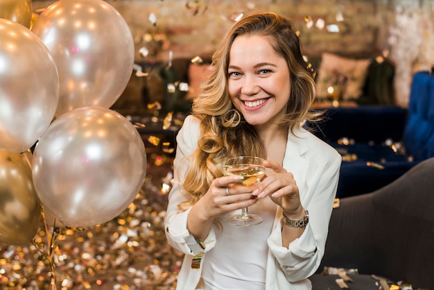 Hübsche lächelnde Frau mit einem Glas Whisky