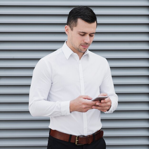 Hübscher Arbeiter, der Telefon überprüft