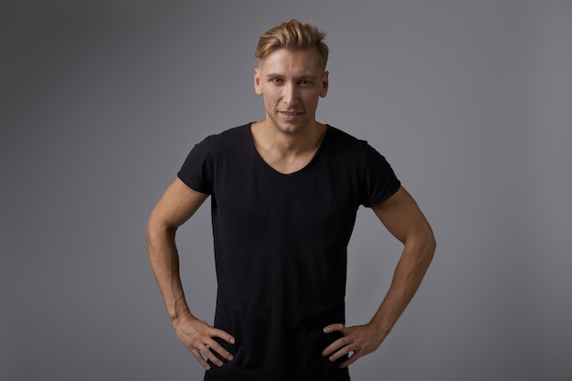 Kostenloses Foto hübscher blonder junger mann, der am studio aufwirft