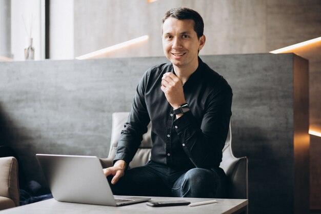 Hübscher Geschäftsmann, der am Computer im Büro arbeitet