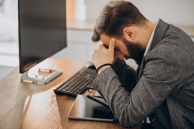 Hübscher Geschäftsmann, der am Schreibtisch arbeitet