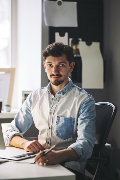 Hübscher Geschäftsmann, der im Büro arbeitet