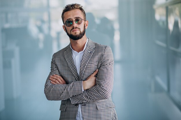 Hübscher Geschäftsmann, der im Büro steht