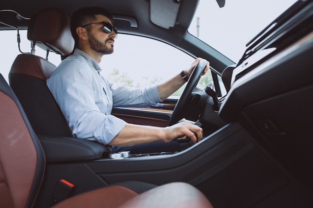 Hübscher Geschäftsmann, der in ein Auto reist