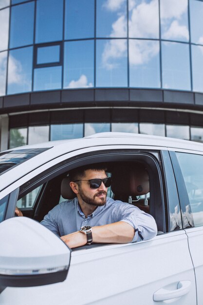 Hübscher Geschäftsmann, der in ein Auto reist