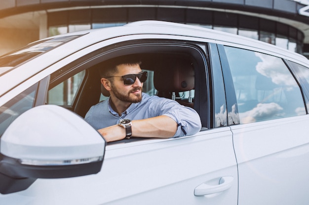 Hübscher Geschäftsmann, der in ein Auto reist