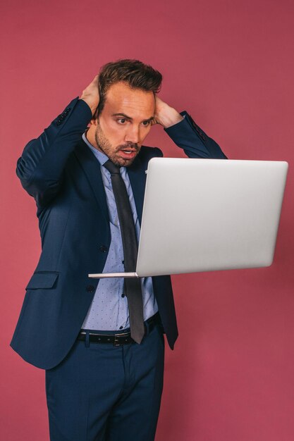 Hübscher Geschäftsmann, der in einem Laptop arbeitet