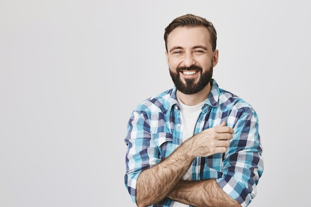 Hübscher glücklicher lächelnder Mann mit Bartlachen