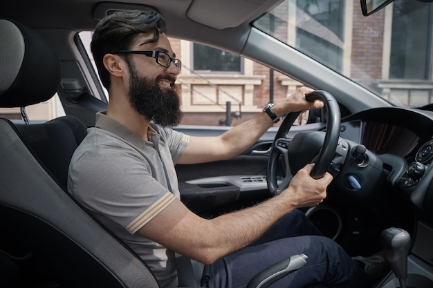 Hübscher, glücklicher Mann, der das Auto fährt